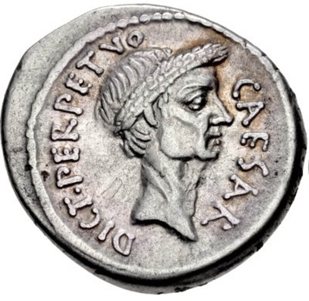 A silver denarius coin featuring Julius Caesar. The legend mentions that Caesar was dictator perpetuo (dictator in perpetuity)